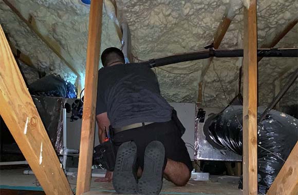 Wyatt Sanders, Certified Home Inspector near Fresno CA, inspecting the HVAC sysem in an attic.